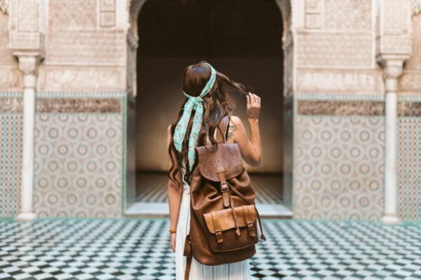 a woman carrying a brown leather rucksack