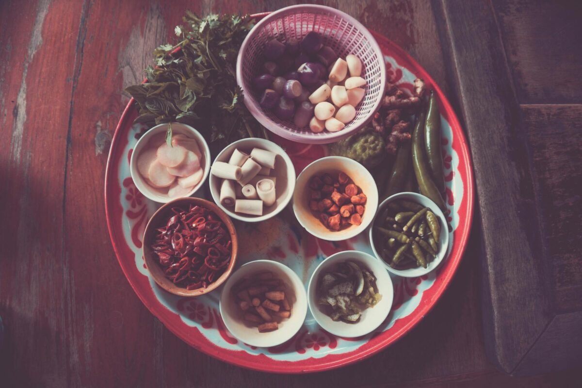 assorted spices on white and red plate on brown wooden table